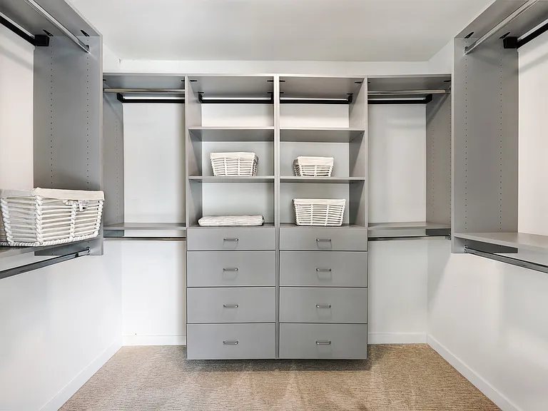 Walk-in closet with built-in shelves and drawers in the primary bedroom