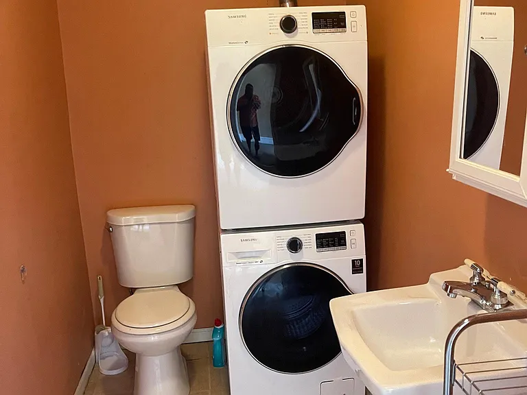 1/2 bathroom with New Washer and Dryer on floor with main bedrooms