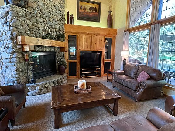 Great Room with vaulted ceiling, large Montana River Rock fireplace, expansive windows