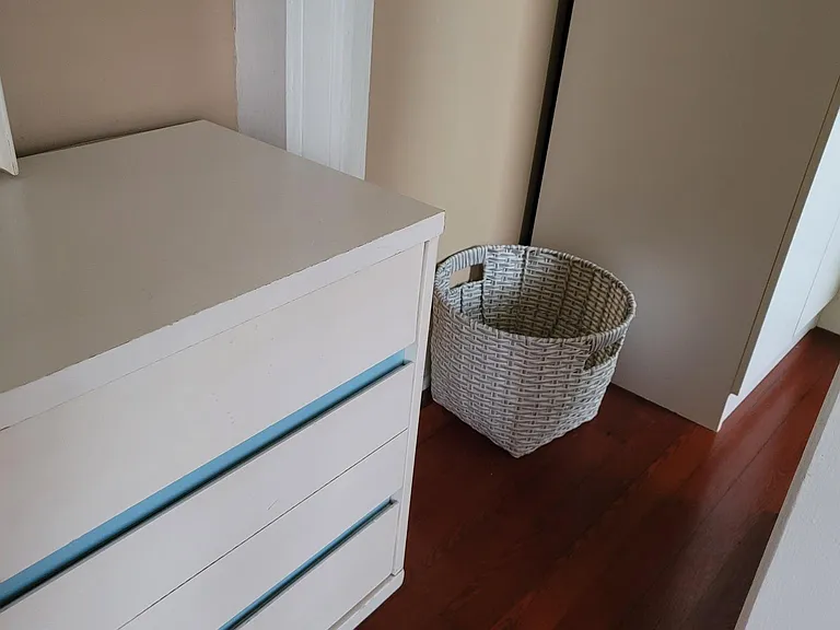 Journeying from the bedroom to the bathroom, find a convenient new laundry basket. The cupboard here at the bathroom entrance is exclusively for landlady's apartment supplies as are the cupboards way overhead here