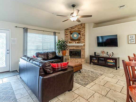 Spacious open concept living room with fire place and 55 inch tv.
