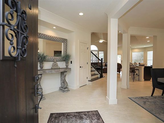 Solid wood "speak easy" door with decorative hardware greet you to 24 inch newer tile flooring. Dining room to the right and living room/study behind doorway.