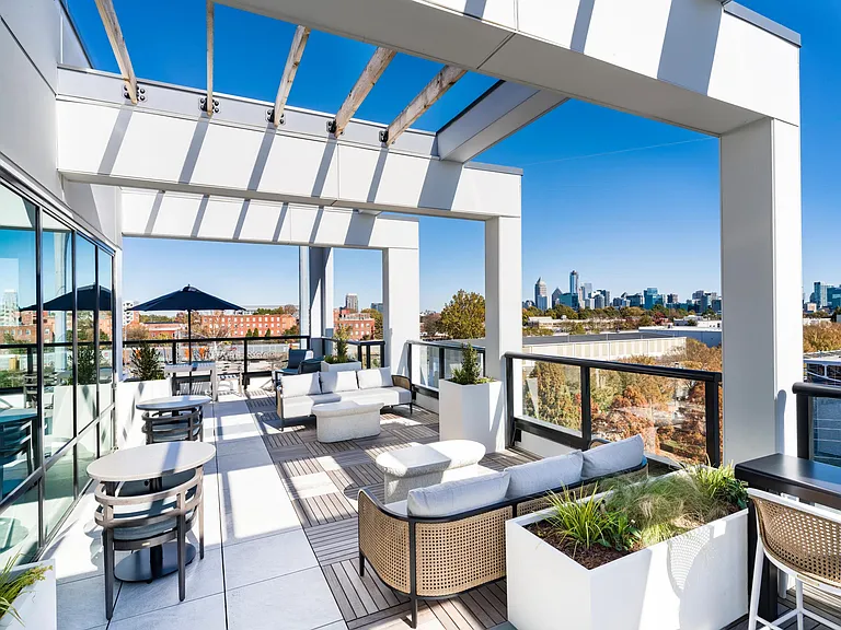 Rooftop lounge seating framed by open-air pergolas and skyline views, offering flexible spaces to gather, relax, or enjoy fresh air overlooking downtown Atlanta.