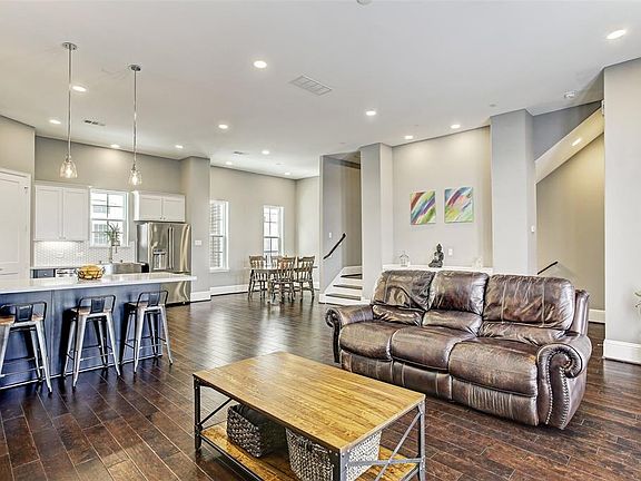 This bright and spacious second-floor living area has high ceiling, recessed lighting, and modern fixtures.