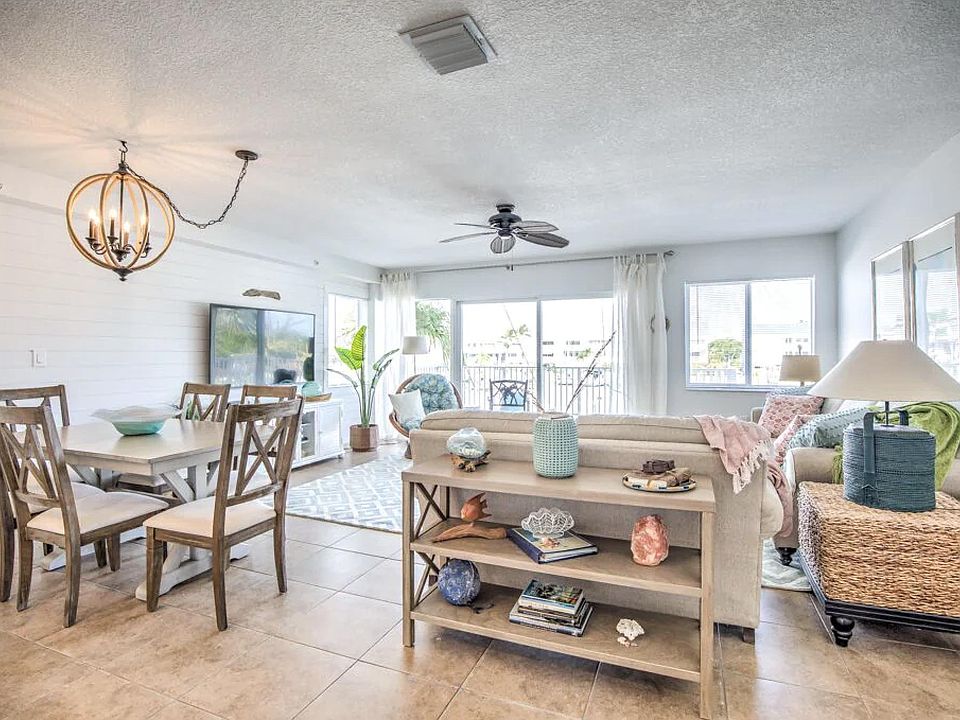 View from stairs-- open living concept with dining (table opens to 8), living, smart TV and access to patio