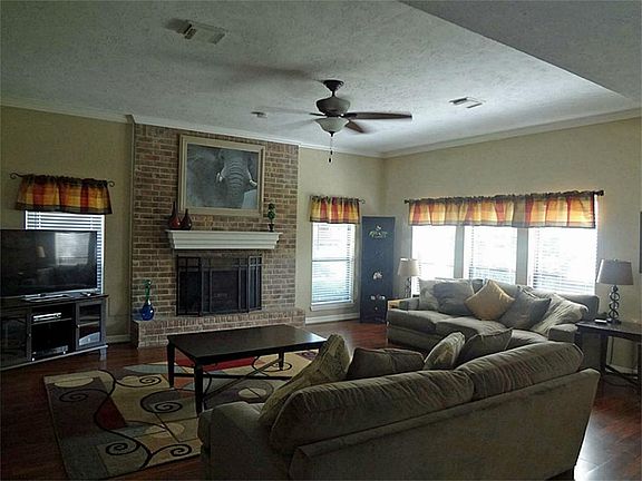 Large family room with fireplace, ceiling fan & laminate floor
