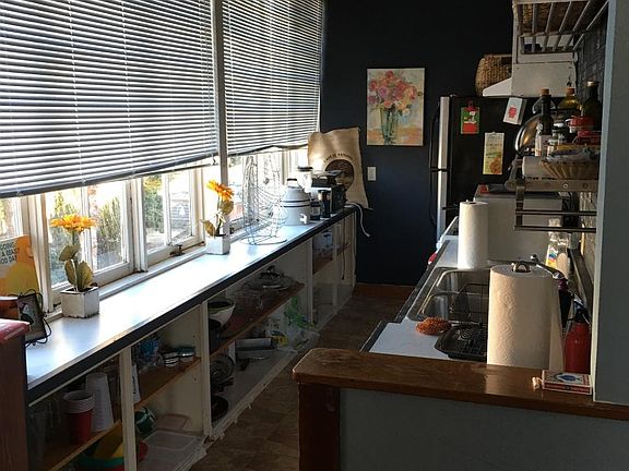fully loaded kitchen complete with microwave, dishes, glasse