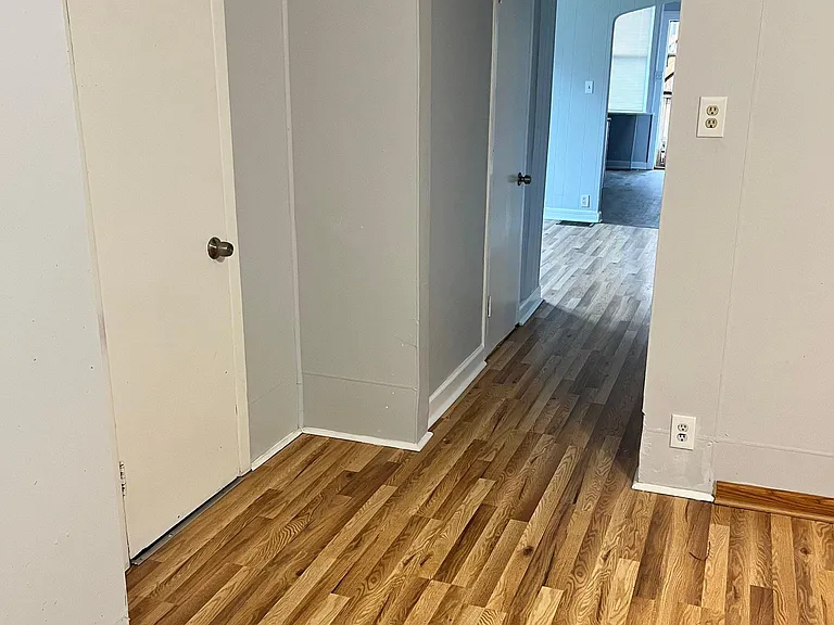 Hallway Towards the Back of the Apartment. First Door is a Coat Closet & Second Door is an Office