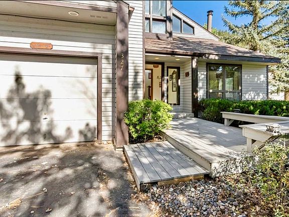 Driveway, one car garage, and front porch with seating