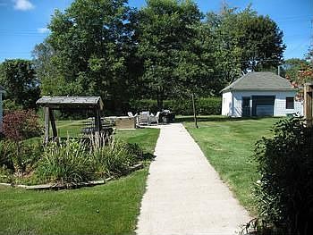 The concrete walkway to the backyard patio and garagestorage bldg., not wide enough for a driveway a
