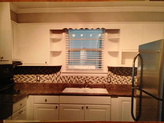 Stainless steel and black appliances in kitchen along with retro charm. Lots of cabinet space.