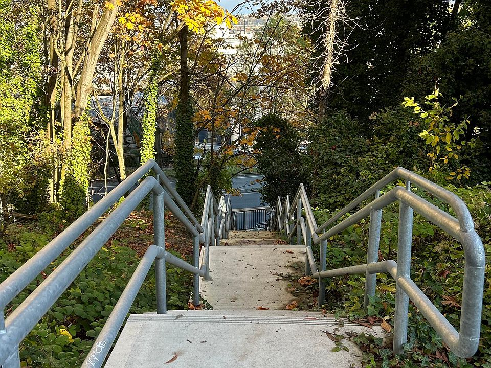 Charming side stairway leading to nearby bus routes. A peaceful walk that connects directly to public transportation, perfect for commuters and cyclists