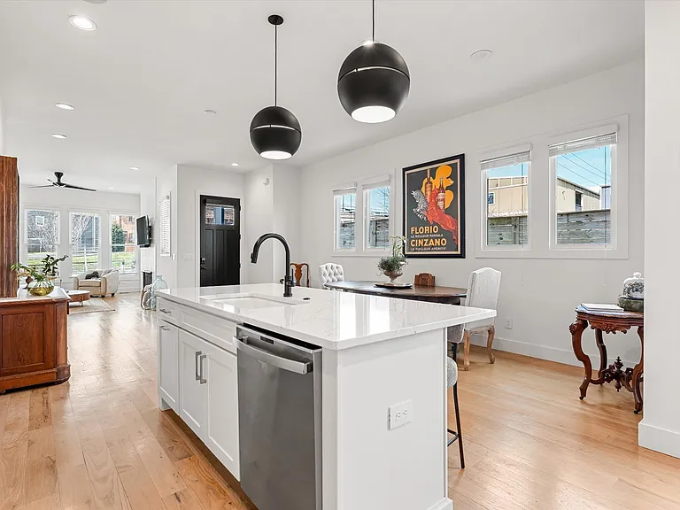Chef's kitchen featuring quartz countertops, large island with seating, and stainless appliances.