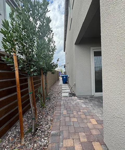walking pavers to trash pad and full pavers to front of home to bring trash cans to street with ease