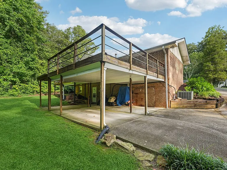 This spacious under deck area creates a sheltered outdoor nook, perfect for storage, projects, or quiet utility, all framed by lush greenery and storybook privacy.