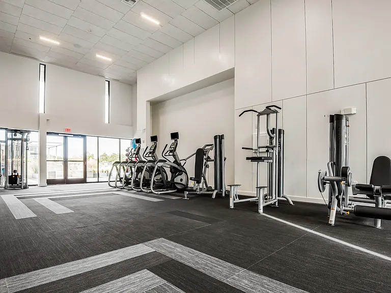 Modern Fitness Center with Ellipticals, Strength Machines, and Natural Light