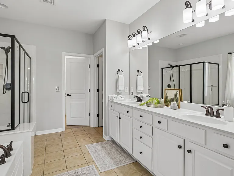 Unwind in the spa-inspired primary bath, where dual vanities, a soaking tub, and separate shower provide the perfect balance of luxury and functionality.