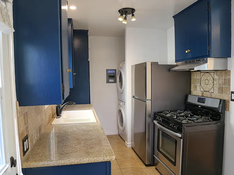 Kitchen features stainless steel appliances and front load laundry.