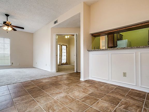 Dining area with view to kitchen (right), 2nd bedroom (middle) and living room (left)