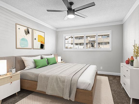 Carpeted bedroom with ceiling fan.