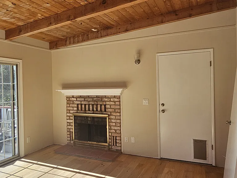 Livingroom w/wood burning fireplace. Sliding door on left leads to a good sized deck.