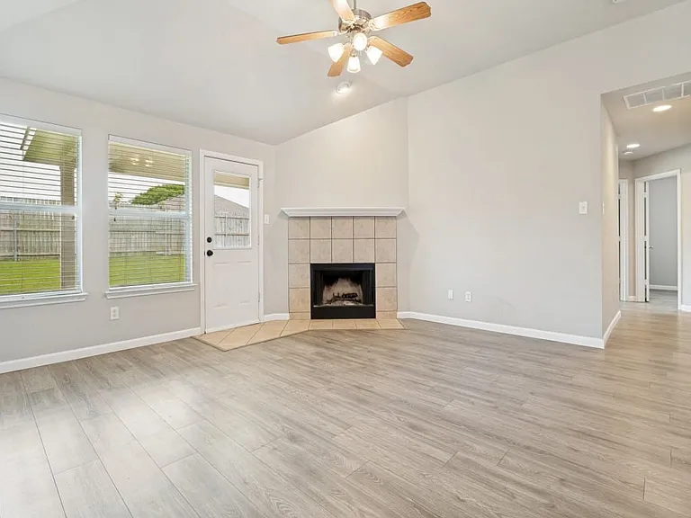 Large windows overlooking backyard and covered patio with fireplace.