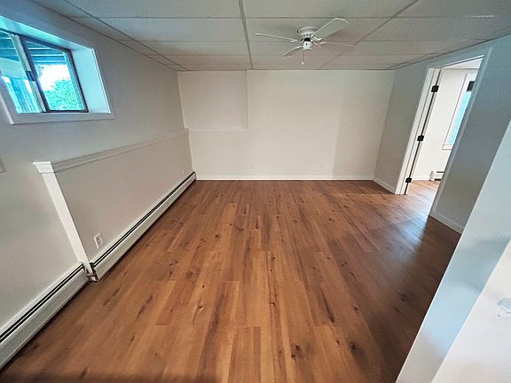 Large living room with window and ceiling fan.