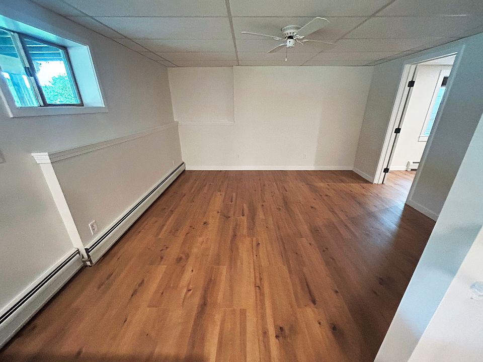 Large living room with window and ceiling fan.