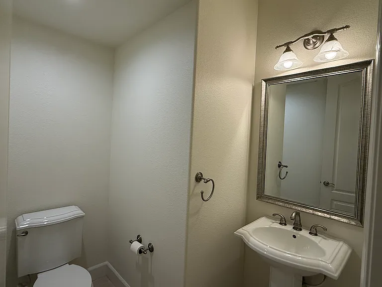 Powder room is conveniently located between the kitchen and the garage access door.