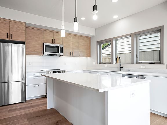 Modern style kitchen with a lot of cabinets and storages All new honey comb top down, bottom up blinds will be installed.