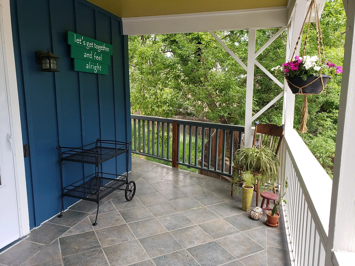 Front porch wraps around to the fenced in back and side yards. Empty log to the one side for extra privacy. - 1630 Cheyenne Blvd