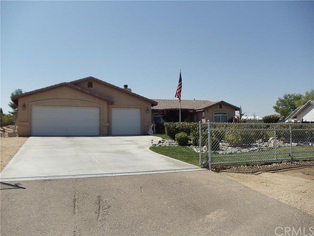 FRONT VIEW WITH CHAIN LINK GATES ,TILE ROOF AND LUSH FRONT LANDSCAPING