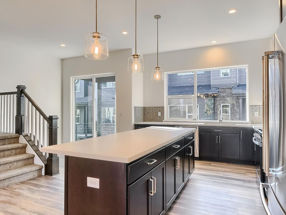 Kitchen behind island with breakfast nook and balcony