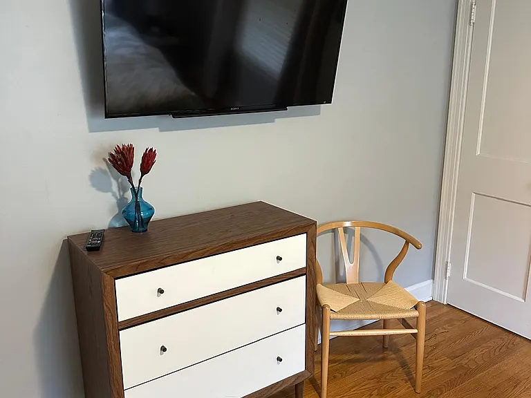 Wall-mounted TV in the bedroom, viewable from the bed.
