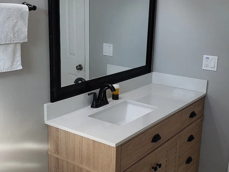 New Remodeled Vanity with New Quartz Countertop and Faucets Looking In.