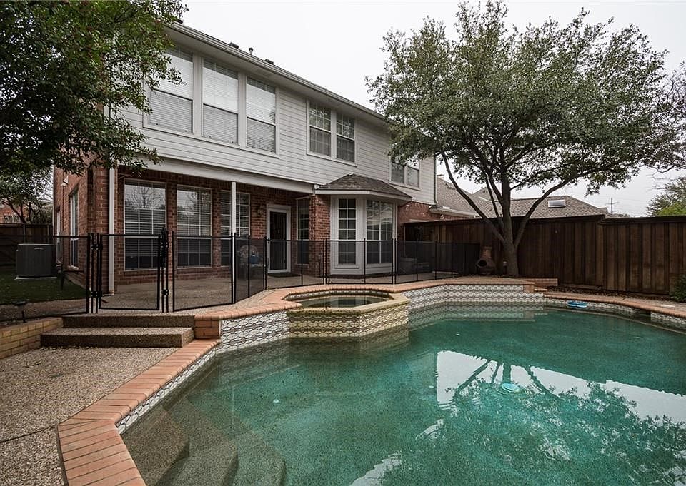 Pebbletech plaster in this beautiful tiered pool with a private 8 ft board on board fence.