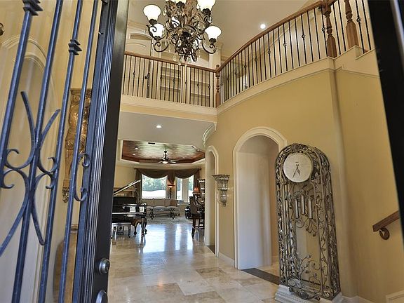Upon entering you find a lovely corridor showcasing custom paint, beautiful floors, elegant archways with crown molding details, high ceilings, and ample lighting!