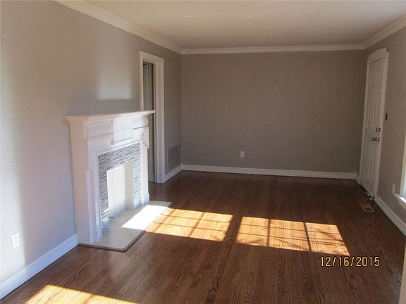 Living room with beautiful fireplace and refinished hardwood floors.