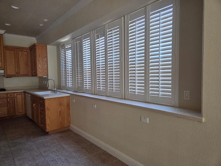 Kitchen lots of storage, and plantation blinds. Light and airy