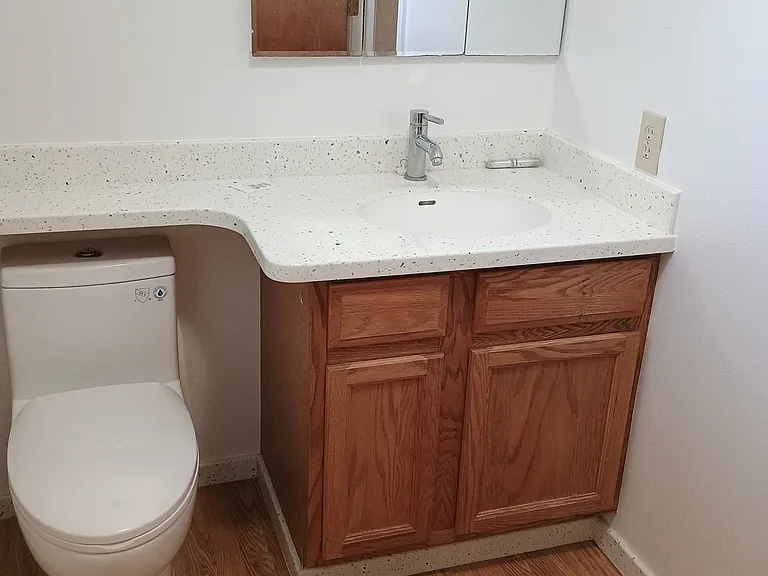Bathroom with new water efficient flushing commode. Solid surface countertop. Medicine cabinet with shelves and 2 drawers in lower cabinet for more storage.