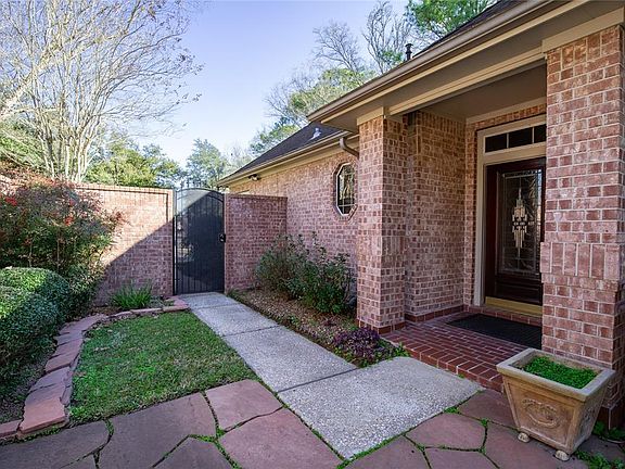 A gate leads to the front entry and backyard. A covered entry leads to the wood and leaded-glass front door.