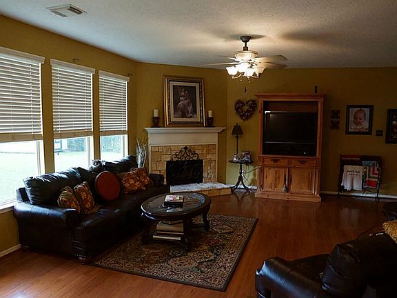 Large family room with wood flooring. Notice the window treatments!