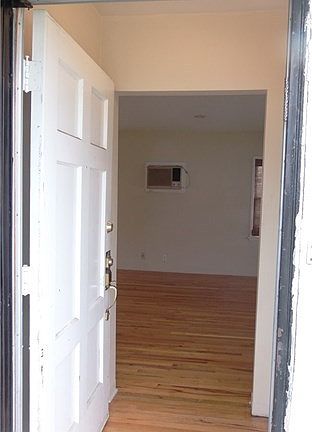 The Entry has a coat closet to the right of front door. Living Room in the background.