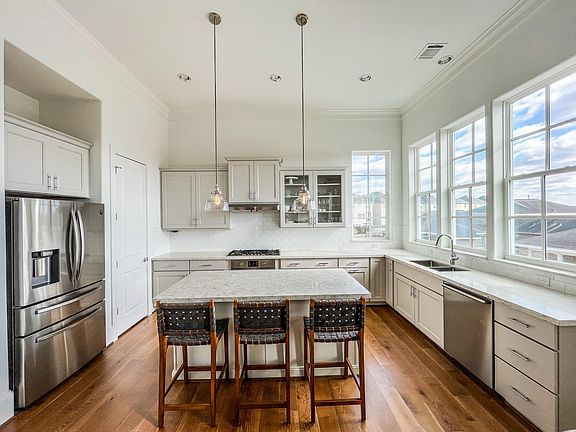 The kitchen features a walk-in pantry, abundant cabinet space, stainless steel Bosch microwave/dishwasher/oven, 5-burner gas cooktop, Samsung refrigerator, quartz countertops, under-cabinet lighting, hidden power outlets. Microwave is hidden in the island