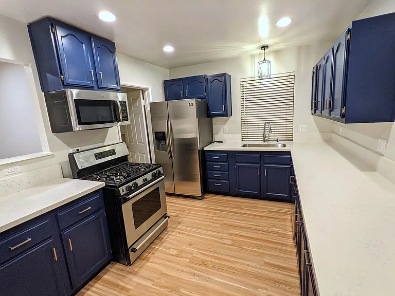 Kitchen with white quartz countertops and stainless steel appliances