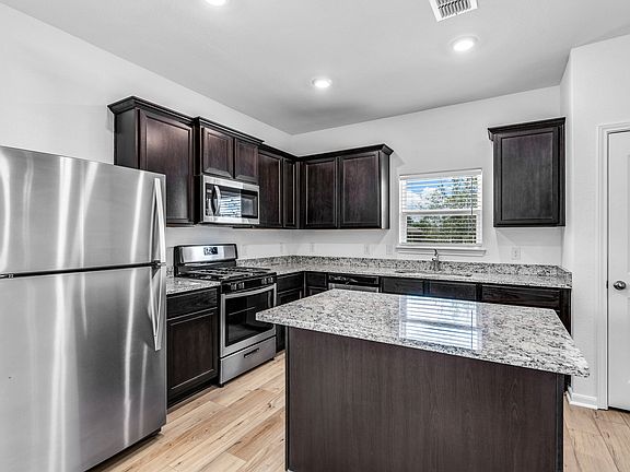 Upgraded kitchen with an island and granite countertops.
