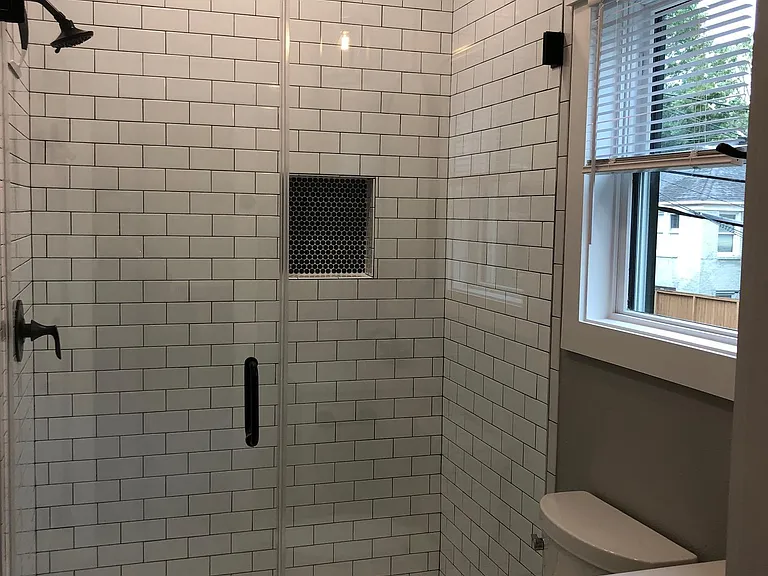 large walk in shower and natural light in addition to overhead can lighting in the shower