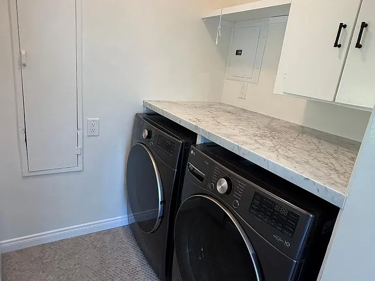 Laundry room with broom closet and door access to side driveway.