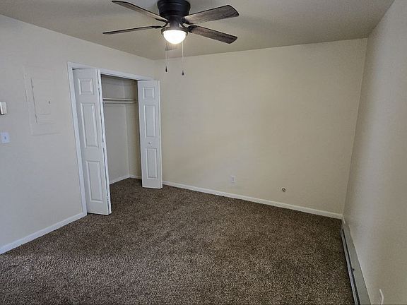 Bedroom with new carpet and ceiling fan.