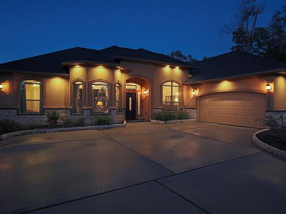 Custom LED fascia lighting provides both security and outstanding curb appeal in the evening. The wide drive and classic architecture give a warm Mediterranean feel to this custom gem.